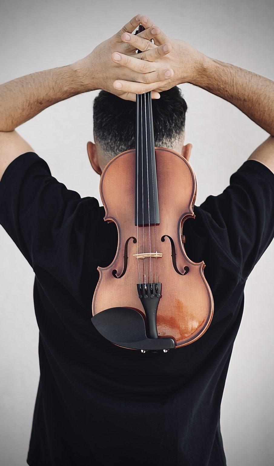 Nico holding an acoustic violin from behind